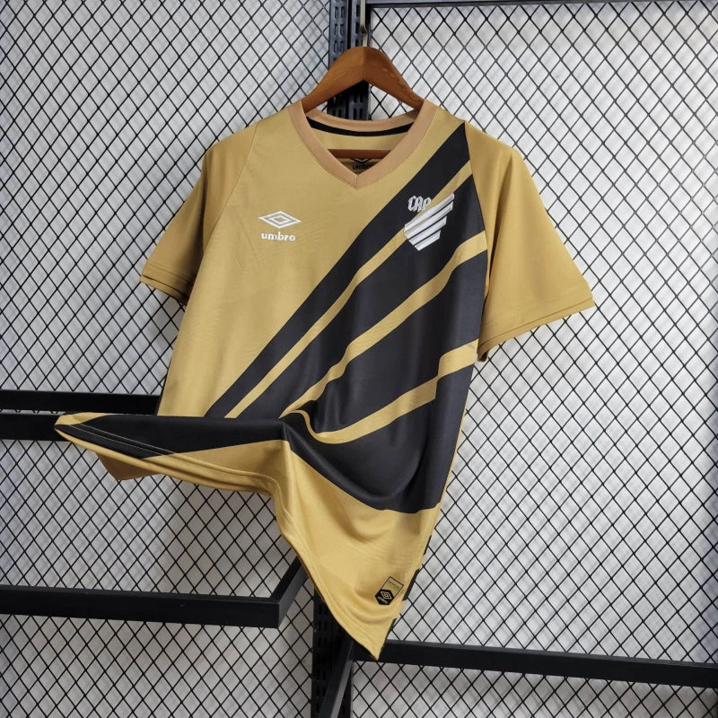 camisa-athletico paranaense-away-ii-2-dourada-umbro-24-25-neymar-messi-cr7-futebol 